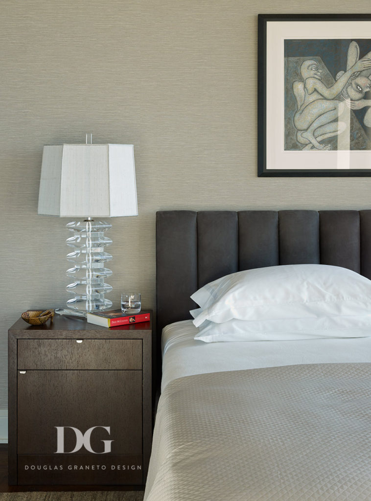 Modern bedroom featuring an Edelman leather headboard, custom upholstery, and accent lamp