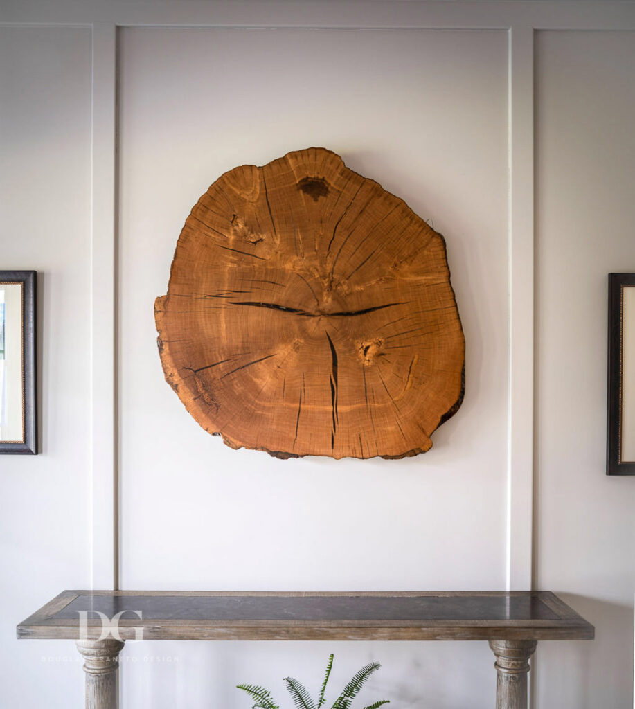 Tree slice wall art hanging over Arhaus console in country club entryway