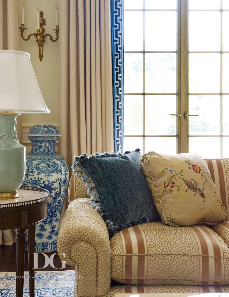 Beige colored couch with blue lamp and vase nearby