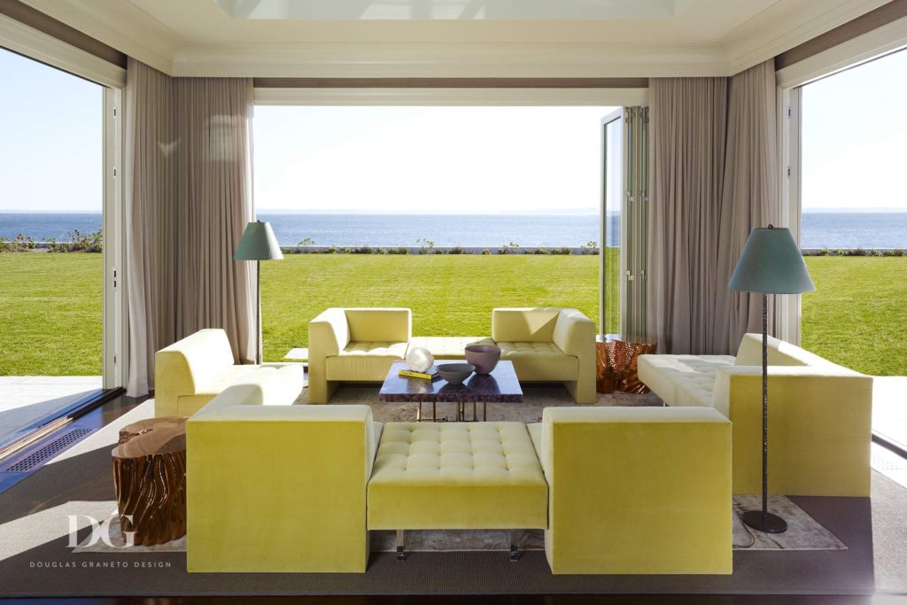 bright yellow furniture in wide open sunroom along the water