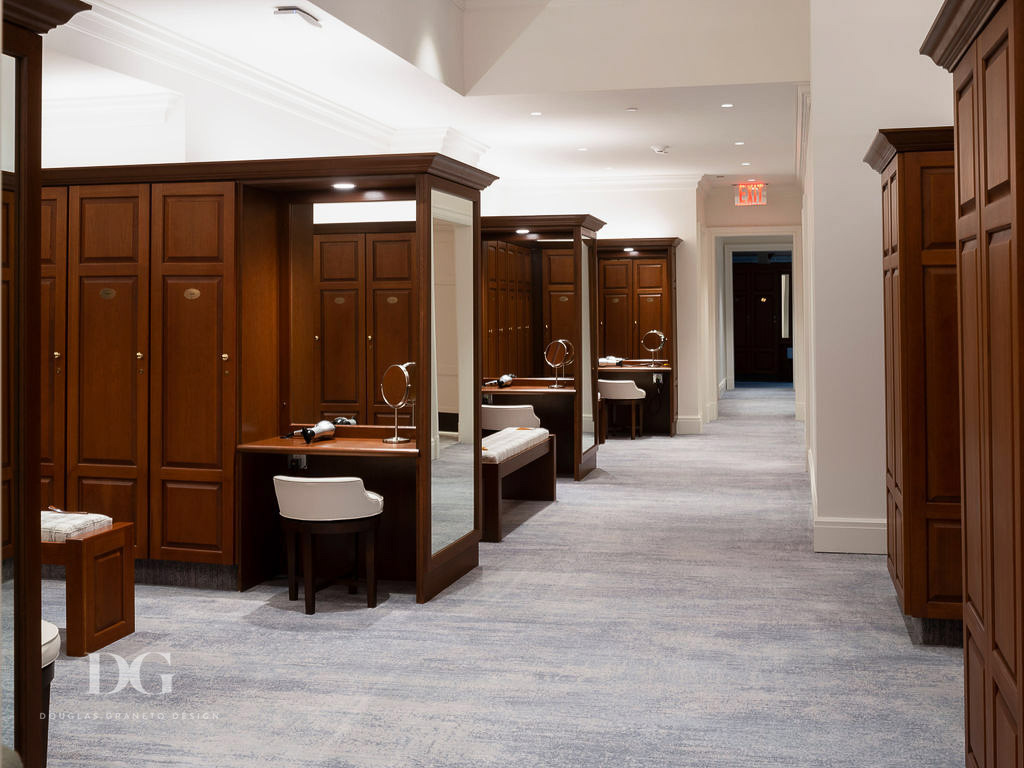 Country club women's locker room with wooden lockers and dressing tables and pale blue Ulster carpet