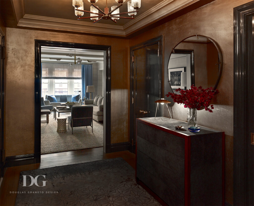 Entryway with plaster walls, dresser and mirror, looking into a living room