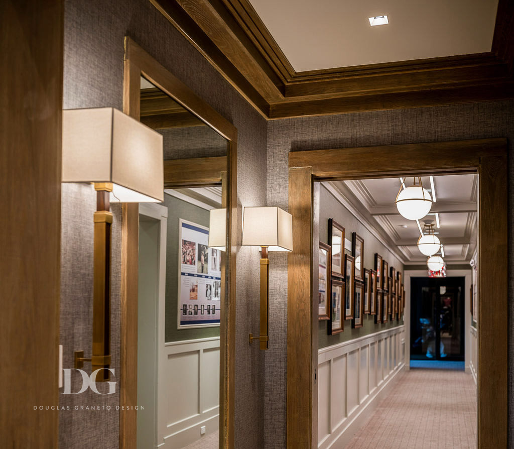 Country club pro shop oak panelled hallway with Hubbardton Forge globe pendants and Circa scones either side of a wall mirror