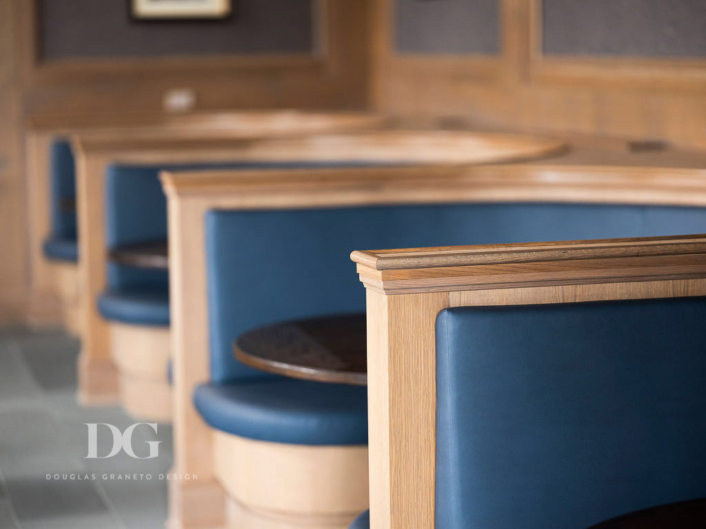 Close up of millwork for row of built in curved blue leather banquettes in country club pub