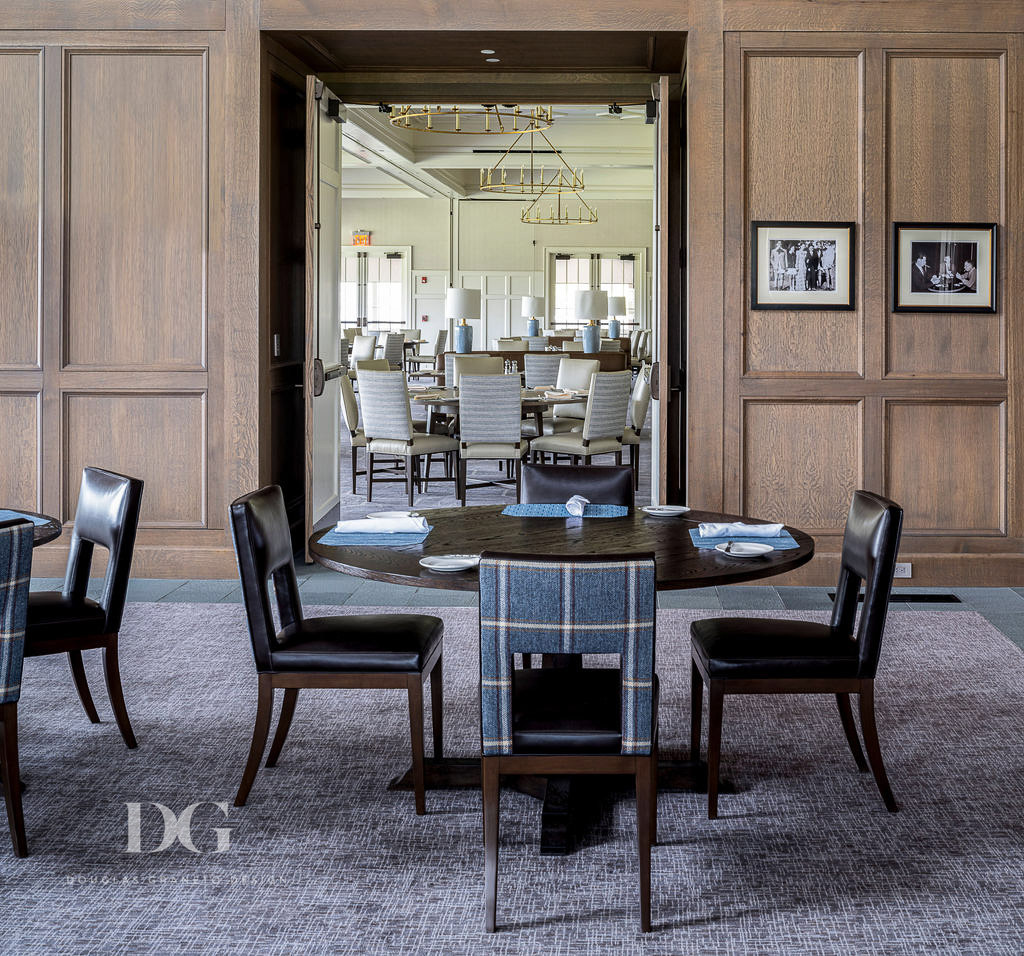 Pub dining table and chairs in brown leather and blue tweed, looking through double doors into a cream country club dining room