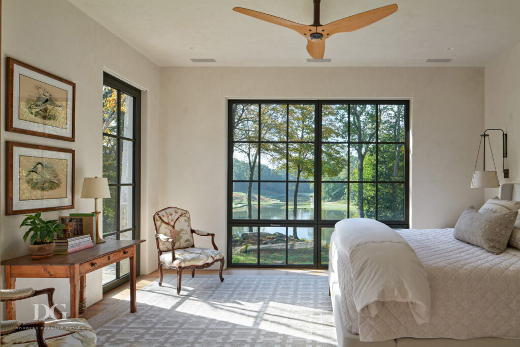 A light bright bedroom with floor to ceiling black trimmed windows, a Holland and Sherry rug and Dimitry bed