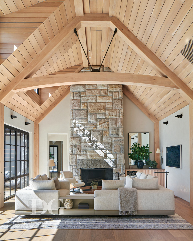 Serene living room with wood paneled vaulted ceiling, stone clad fireplace, and Minotti DDC sectional.