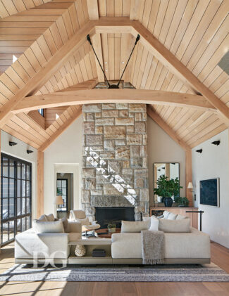 Serene living room with wood paneled vaulted ceiling, stone clad fireplace, and Minotti DDC sectional